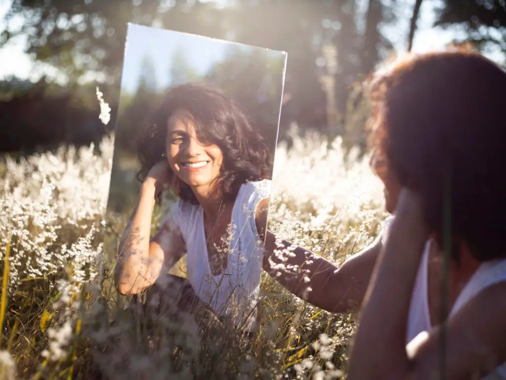 woman using a mirror outside to create cute and aesthetic self portrait photography
