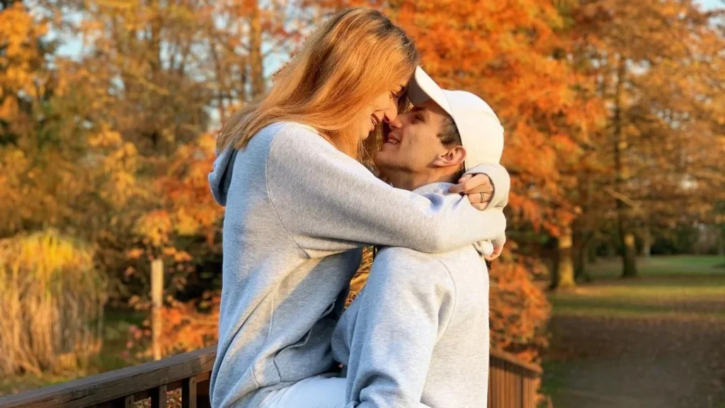 cute boyfriend holding girlfriend in an autumn setting in a couple fall photoshoot