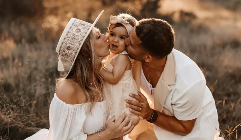 family with a nice family photoshoot outfit, kissing their baby on the cheek