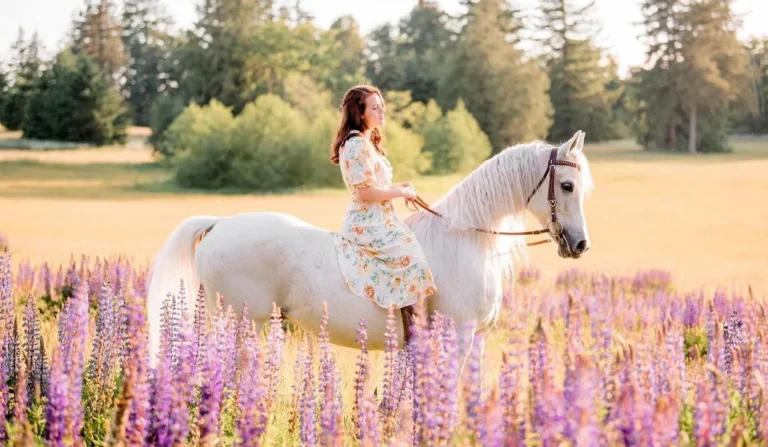 girl riding on a horse through a field of flowers, posing for horse portrait photography