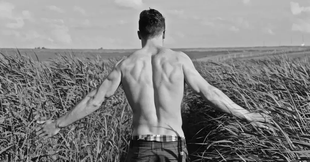 boudoir photography for men; man going through a field of wheat