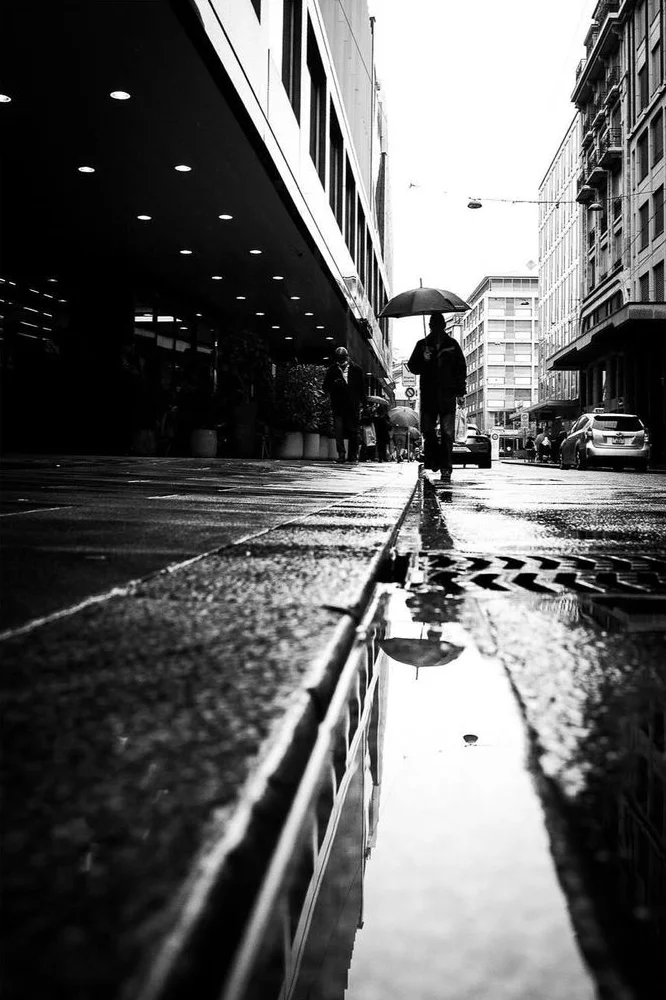 man walking in rain in an urban setting, urban photography