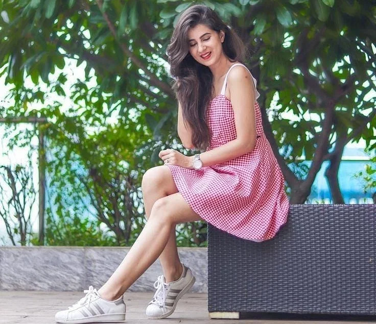 girl in a nice dress and sneakers taking a cute picture in the outside, smiling