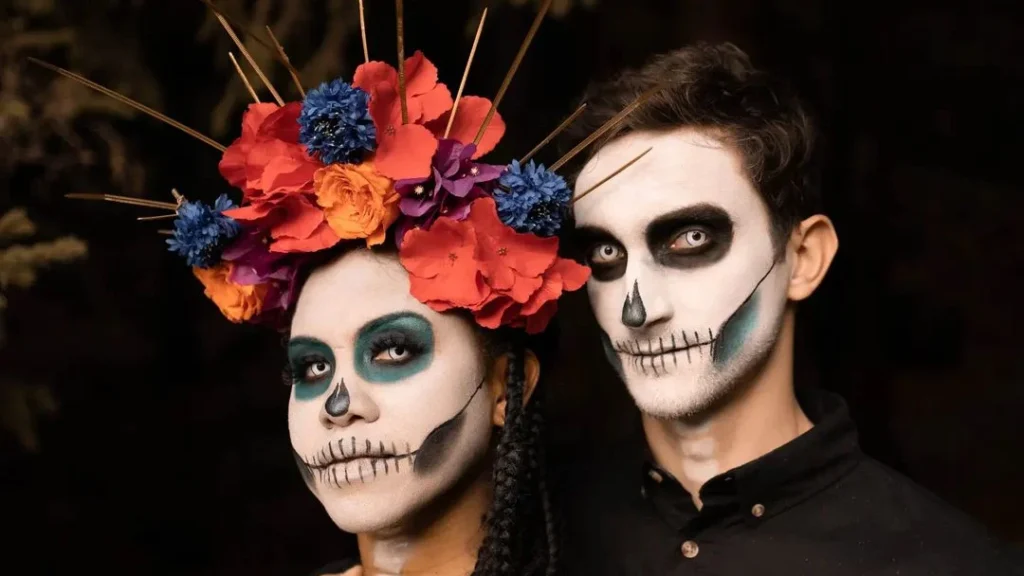 couple with halloween make-up are looking in the camera and provide couple halloween photoshoot ideas in front of a black and dark background