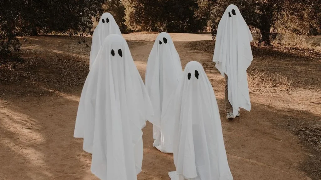 spooky ghost family wanders through the nature, posing for family halloween photoshoot