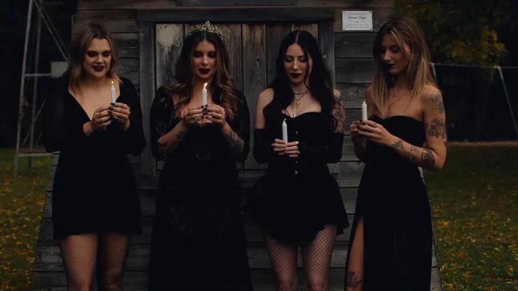 four witches posing with a candle to get beautiful witchy photography