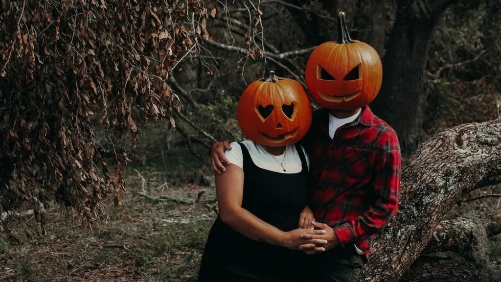 couple in a forest wearing pumpkin heads to do a cute couple photoshoot with boyfriend and girlfriend on halloween
