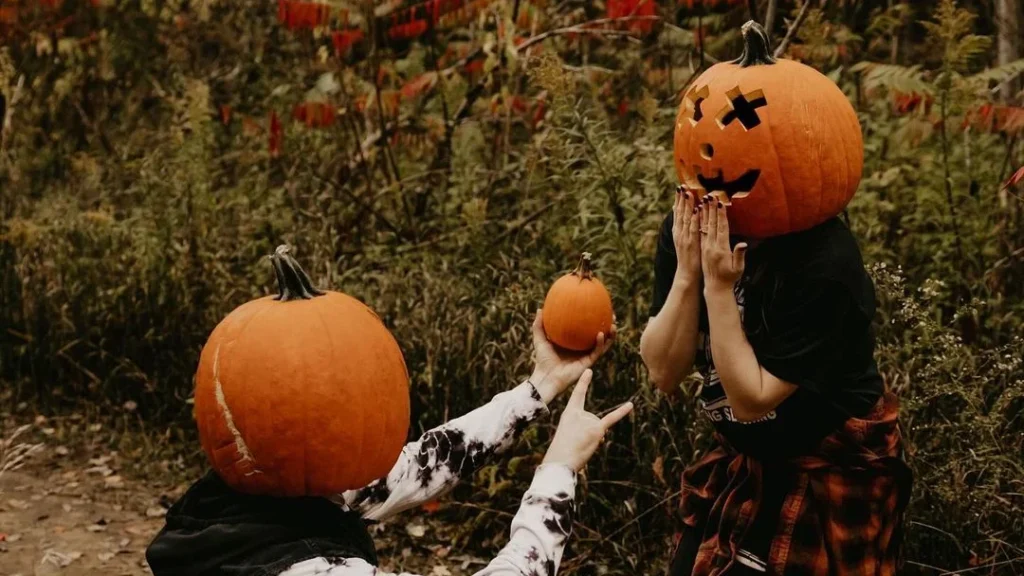couple wearing pumpkin heads doing poses like proposing with a pumpkin, to get the best photos