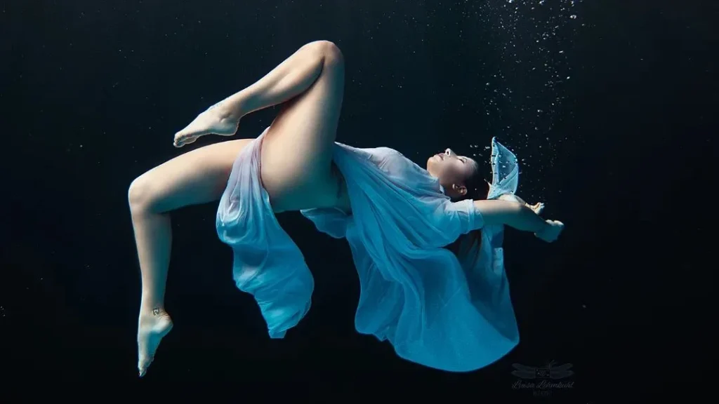 underwater boudoir photography with long clothes floating in the water