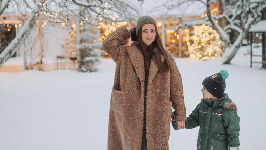 mom and son posing for winter family photography in front of beautiful lights