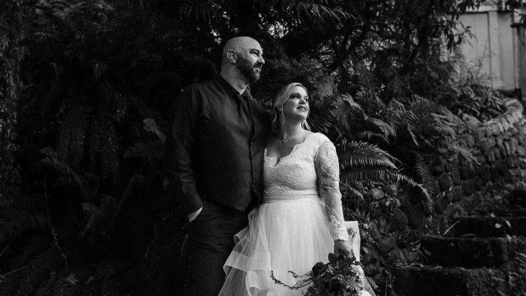 couple posing for moody wedding photography on their wedding day by looking in the distance and creating a moody atmosphere