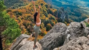 girl doing yoga on a hiking trip, view over beautiful mountains, best camera for hiking, amazing panorama view
