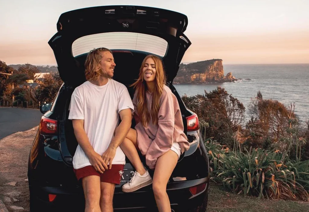 cute couple on a roadtrip photoshoot, photography at the shore with sunny weather